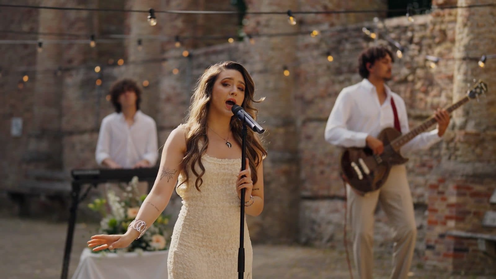 Gwen Kaihatu zingt Diamonds met gitarist en toetsenist onder lichtsnoeren