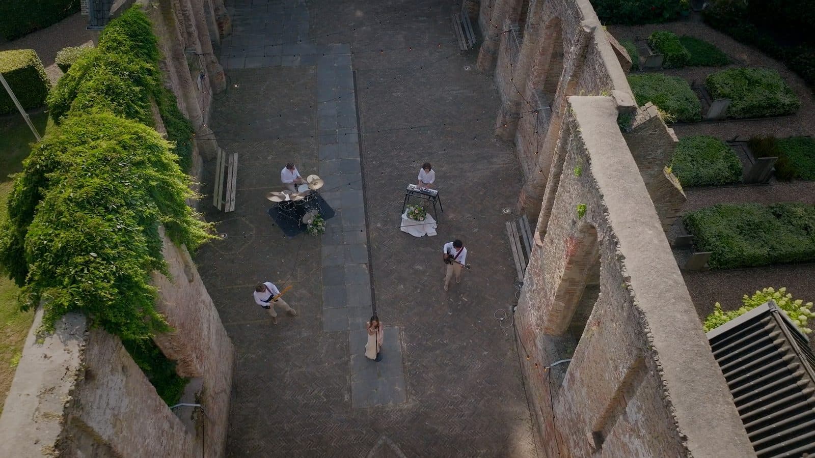 Dronebeeld van boven op de band in de Ruïnekerk tussen het groen